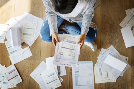 man looking at scattered papers on the floor