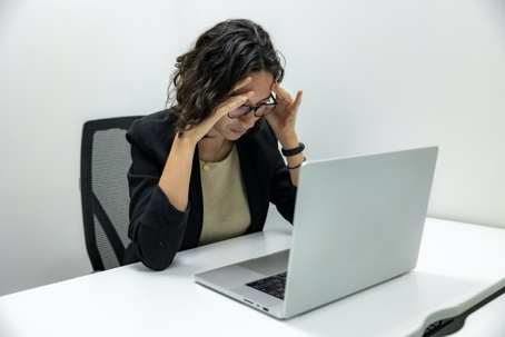 stressed looking person sitting at desk with laptop