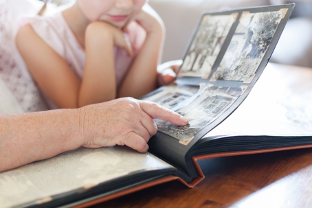Grandma pointing to pictures in photo album