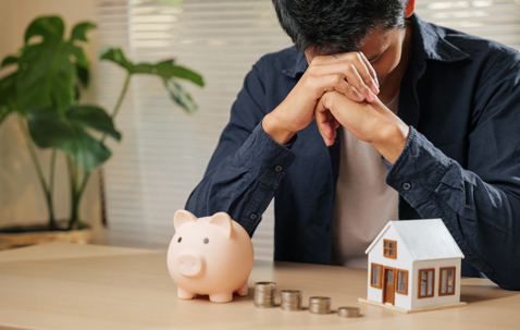 Financial stress concept with house asset and limited cash savings