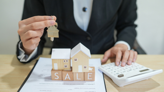 Person calculating mortgage options while planning to sell a home before foreclosure.
