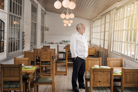 Restaurant owner standing in an empty dining area facing financial challenges.